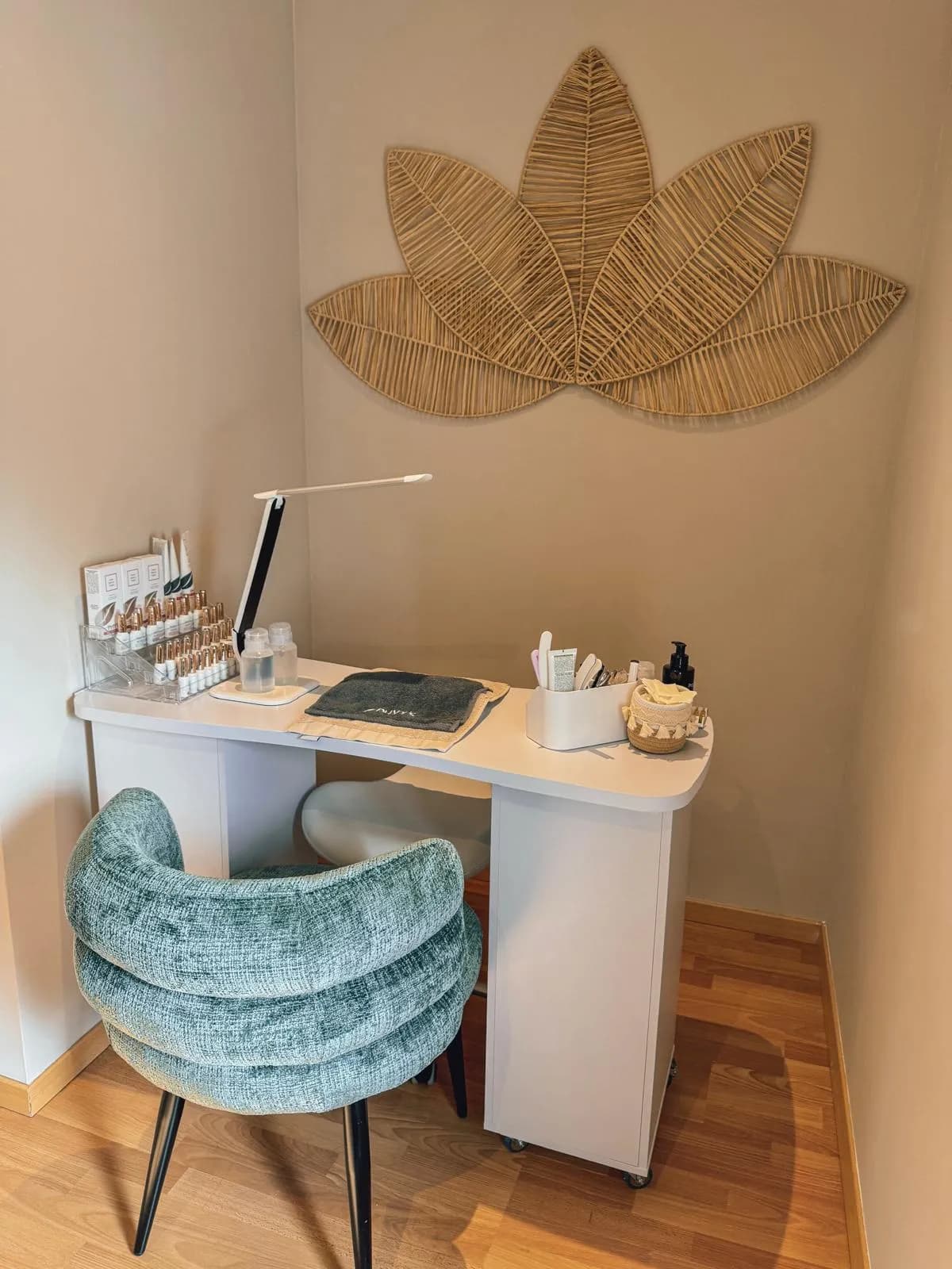 Espace de travail soigné chez Taraya Institut — bureau manucure, fauteuil en velours et décoration murale en bois